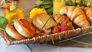A breakfast setting with bread, strawberries, and juice.