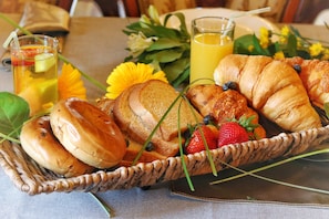 A breakfast setting with bread, strawberries, and juice.