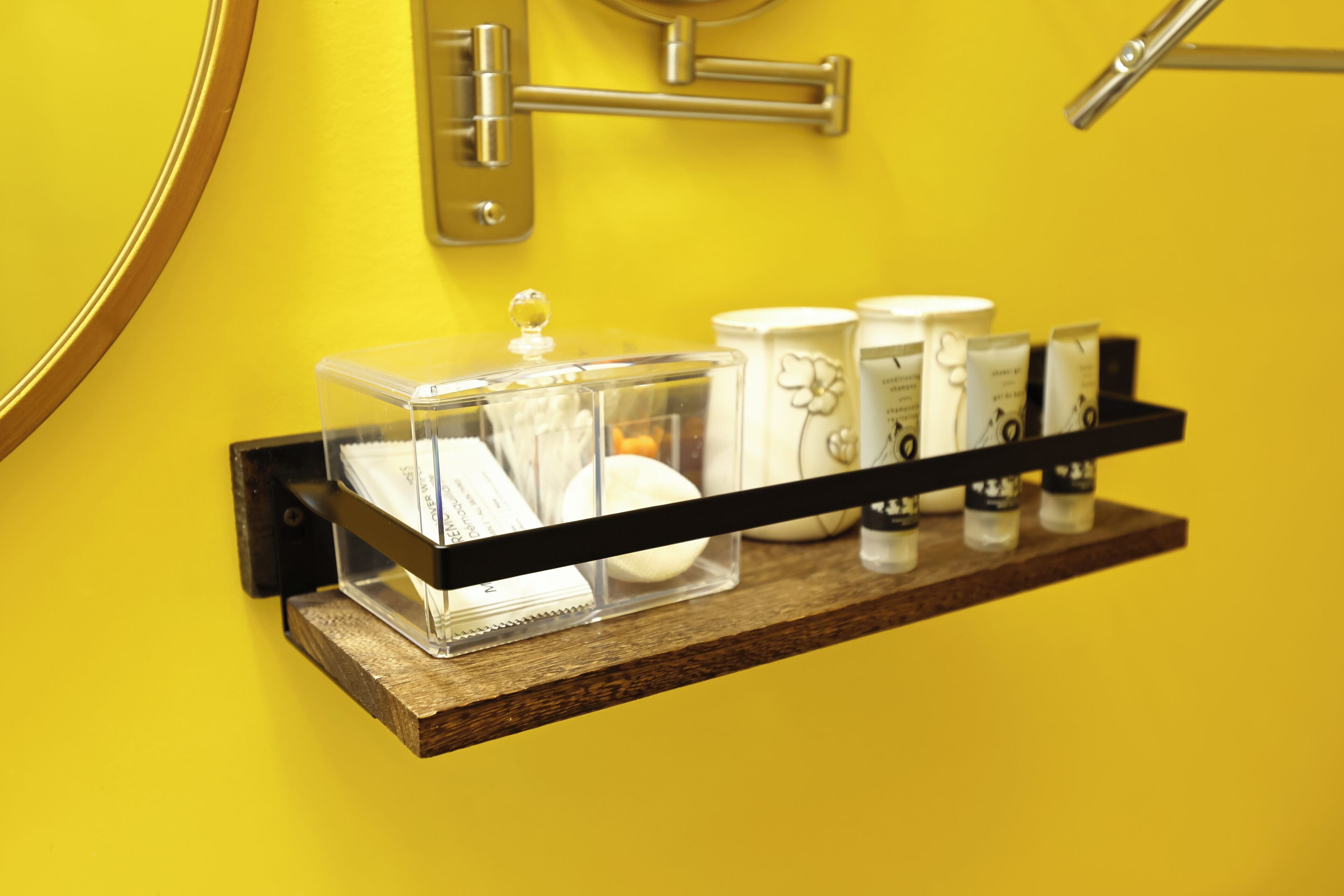 A bathroom shelf with toiletries and a towel dispenser.