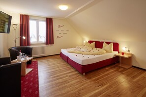 A bedroom with a bed, a desk, a chair, a radiator, and a window with curtains. - Hotel Restaurant Lindenhof (Braeunlingen)