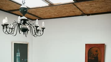 A staircase with a metal railing, a chandelier, and two framed pictures on the wall.