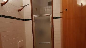 Un baño pequeño con inodoro, bidé y cabina de ducha.