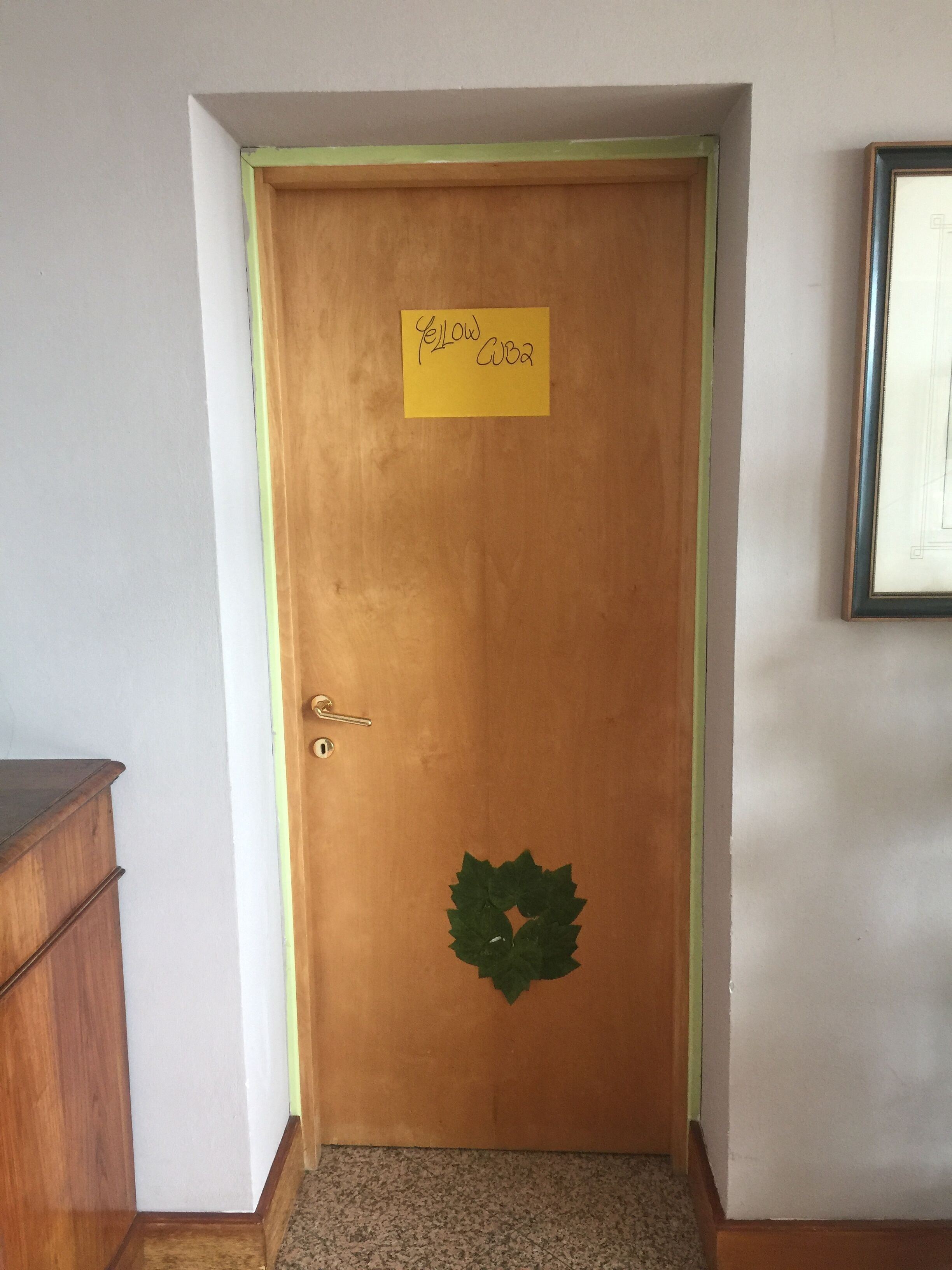 A wooden door with a yellow sign that reads "Yellow Cuba."