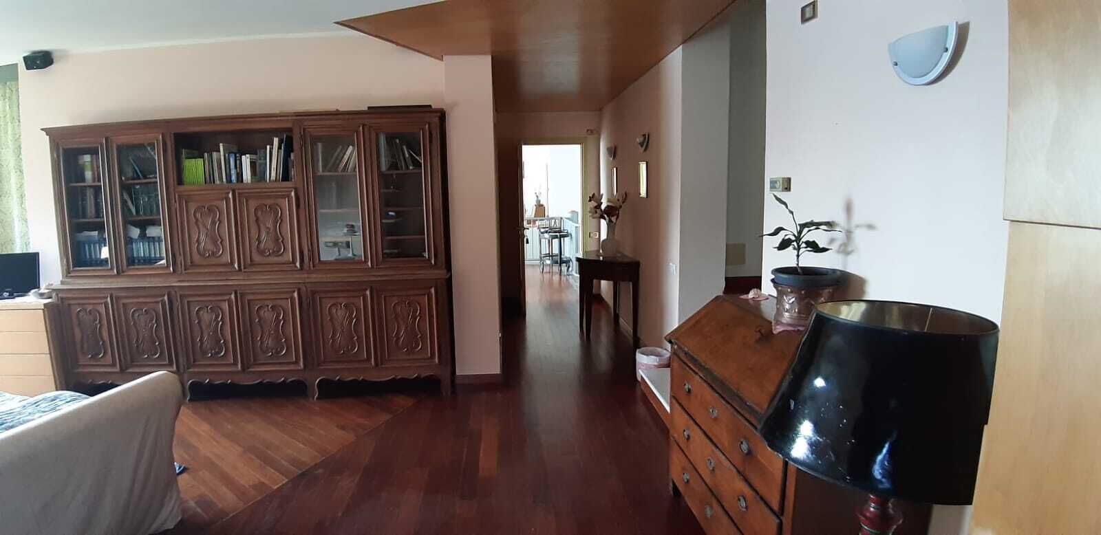 A spacious room with a wooden cabinet, a dresser, and a lamp.
