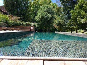 Piscine extérieure en saison, chaises longues
