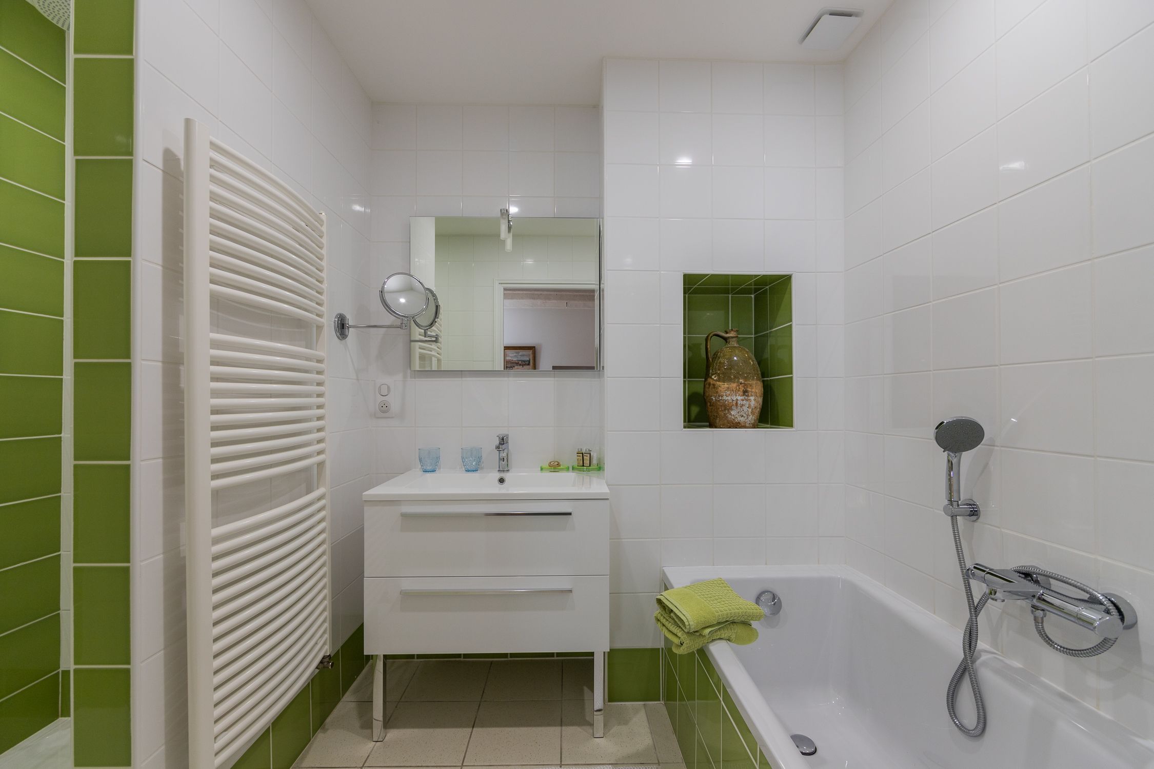 A bathroom with a white sink, mirror, and shower.