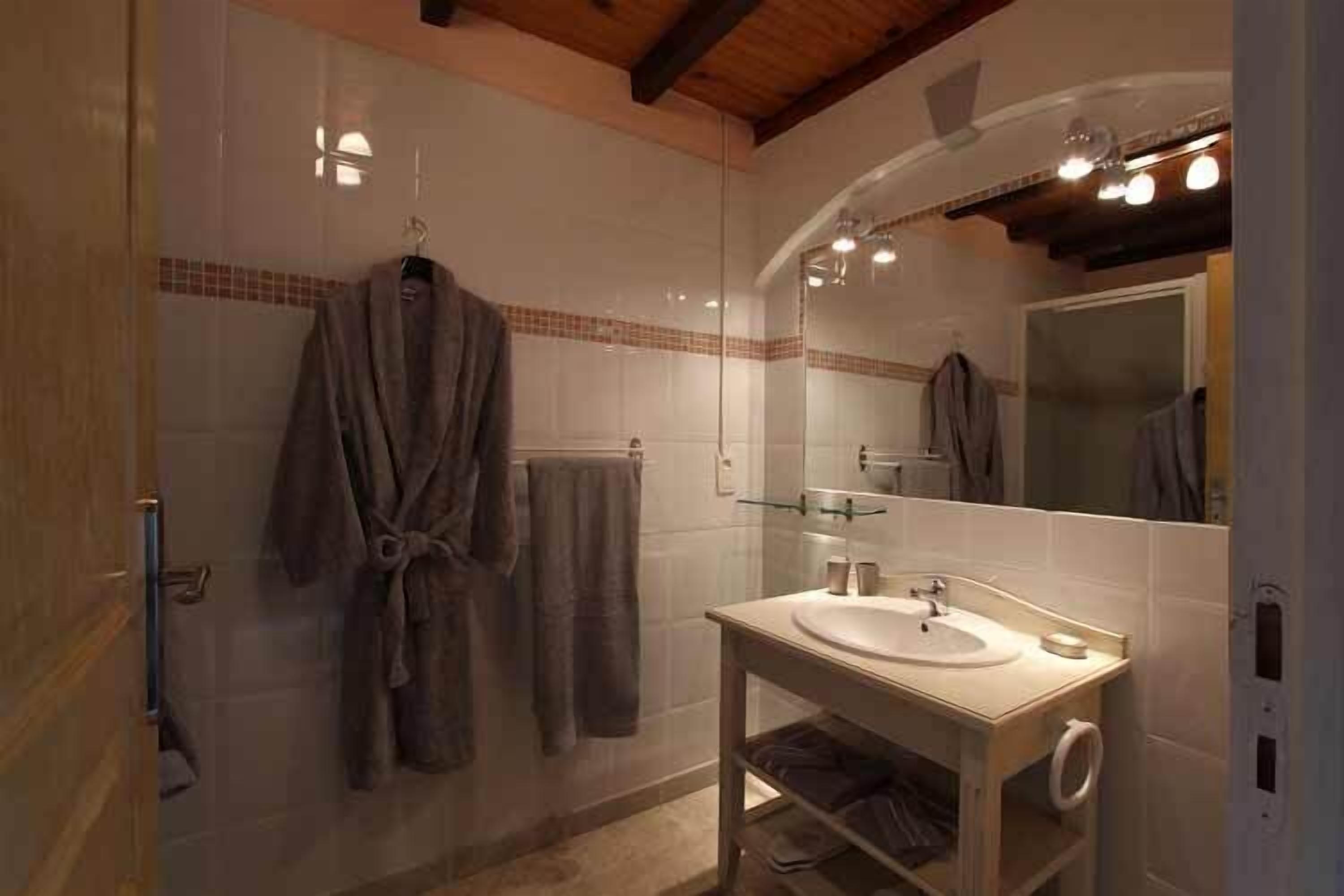 Une salle de bain avec une douche, un lavabo et un miroir.
