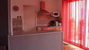 Une cuisine compacte équipée d’un four à micro-ondes, d’une cuisinière et d’un évier.
