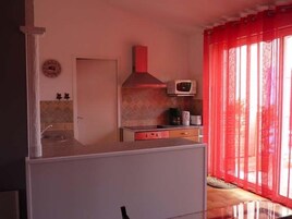 Una cocina compacta con microondas, estufa y lavamanos.
