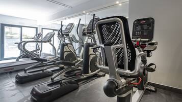 Una palestra con diverse macchine per esercizi, tra cui tapis roulant ed ellittiche.