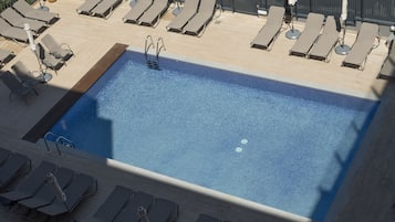 Piscine couverte, piscine extérieure, parasols de plage, chaises longues