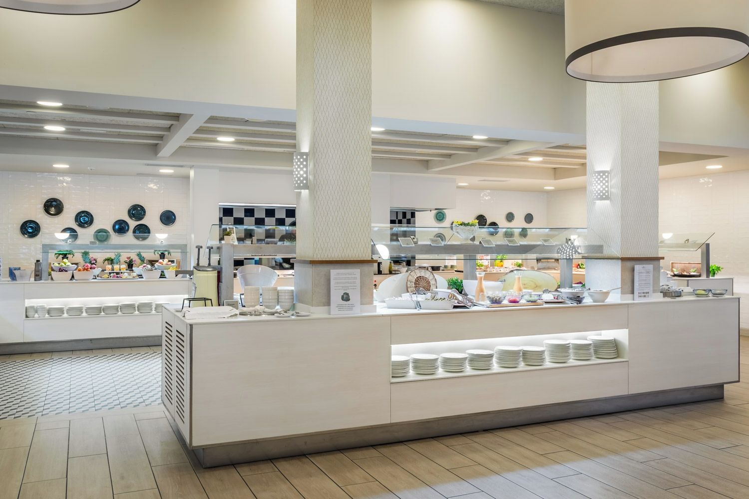 Un buffet moderne, doté de plusieurs points de service, d’un présentoir central et d’un sol carrelé, propre et élégant.