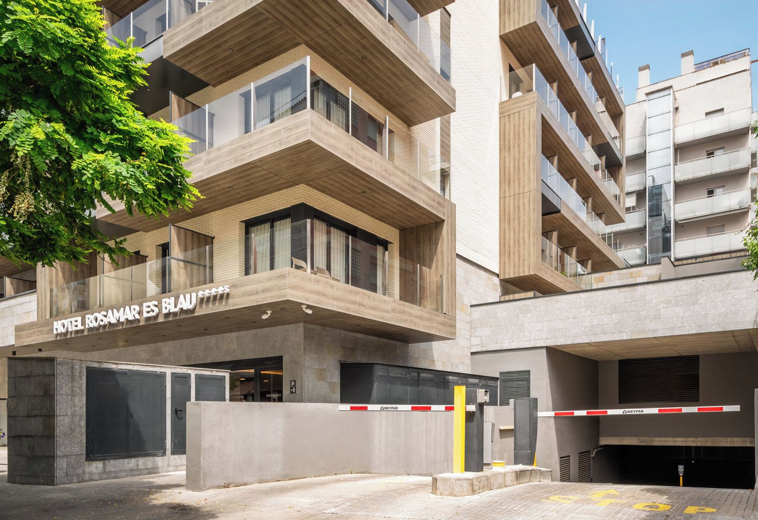 A modern hotel building with a prominent sign reading 'HOTEL ROSAMAR ES BLAN'.