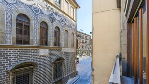 Une rue étroite bordée d’un immeuble doté de fenêtres en arc et de décorations complexes en carreaux de céramique.