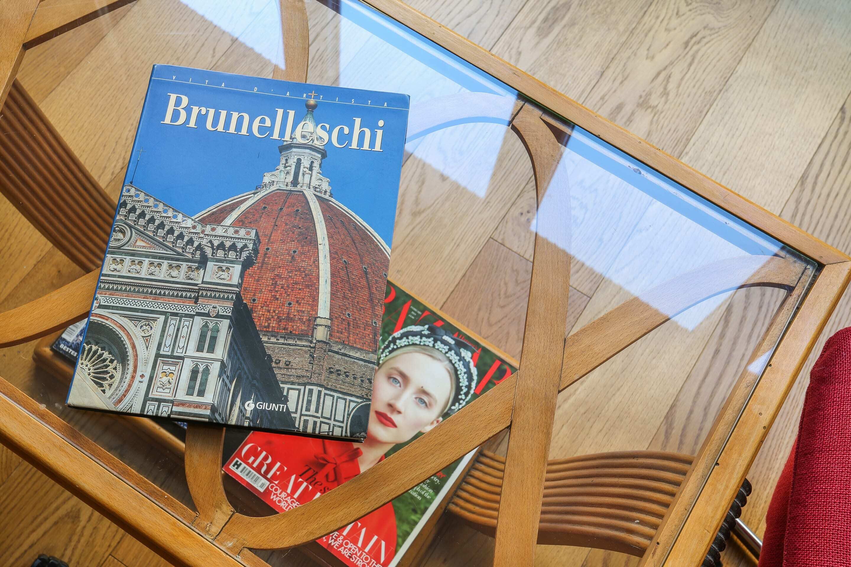 A glass table with a book titled 'Brunelleschi' and another book with a red cover.