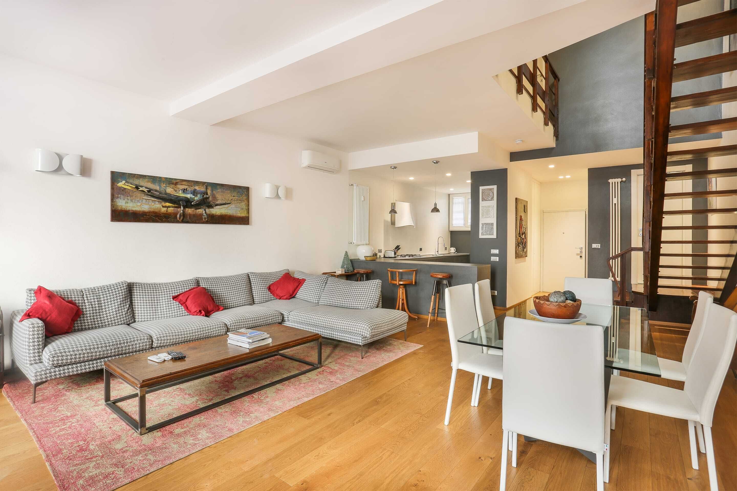 A modern living room with a sofa, coffee table, and dining area.