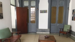 A room with a wooden table, two chairs, and a door with a brick pattern. - Claridge Hotel (Montevideo)