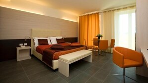 A modern hotel room with a large bed, bedside tables, a desk, and a chair. - Hotel Parco dei Principi (Grottammare)
