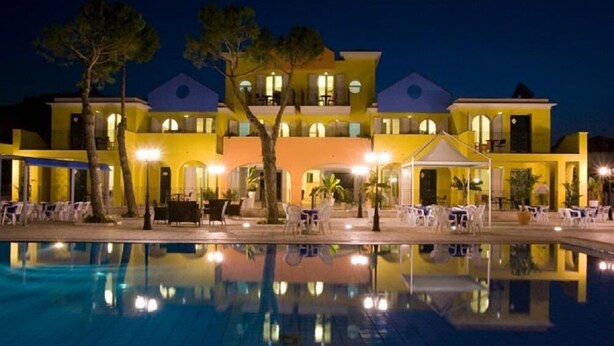 A hotel with a pool, outdoor seating, and a well-lit facade. - Hotel Parco dei Principi (Grottammare)
