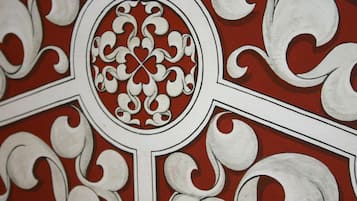 A detailed architectural design with ornate white patterns on a red background.