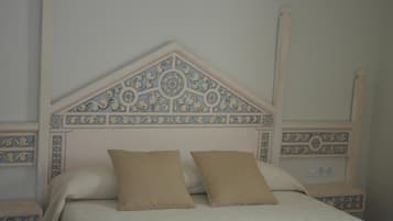 A bed with a decorative headboard, two pillows, and bedside tables.