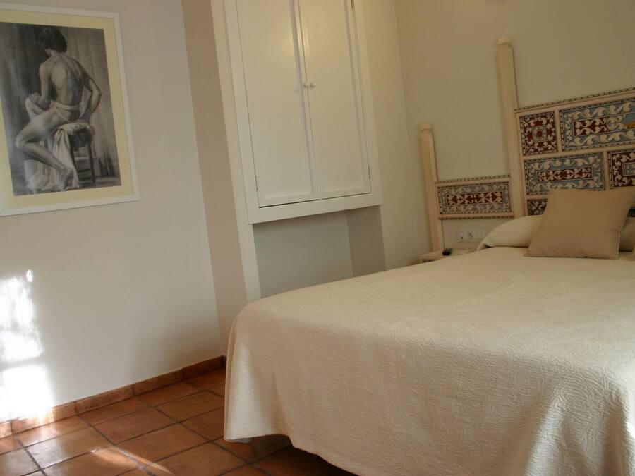 Un dormitorio con cama, armario y un cabecero decorativo.