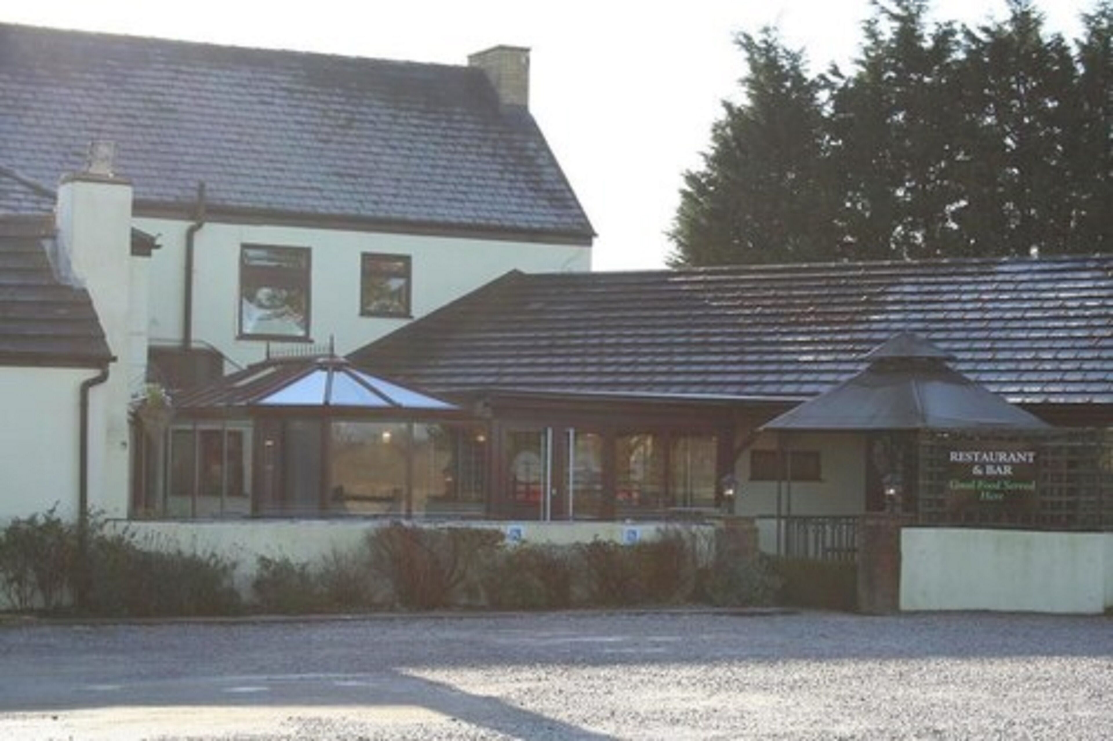 A building with a covered outdoor seating area and a sign that reads "RESTAURANT & BAR."