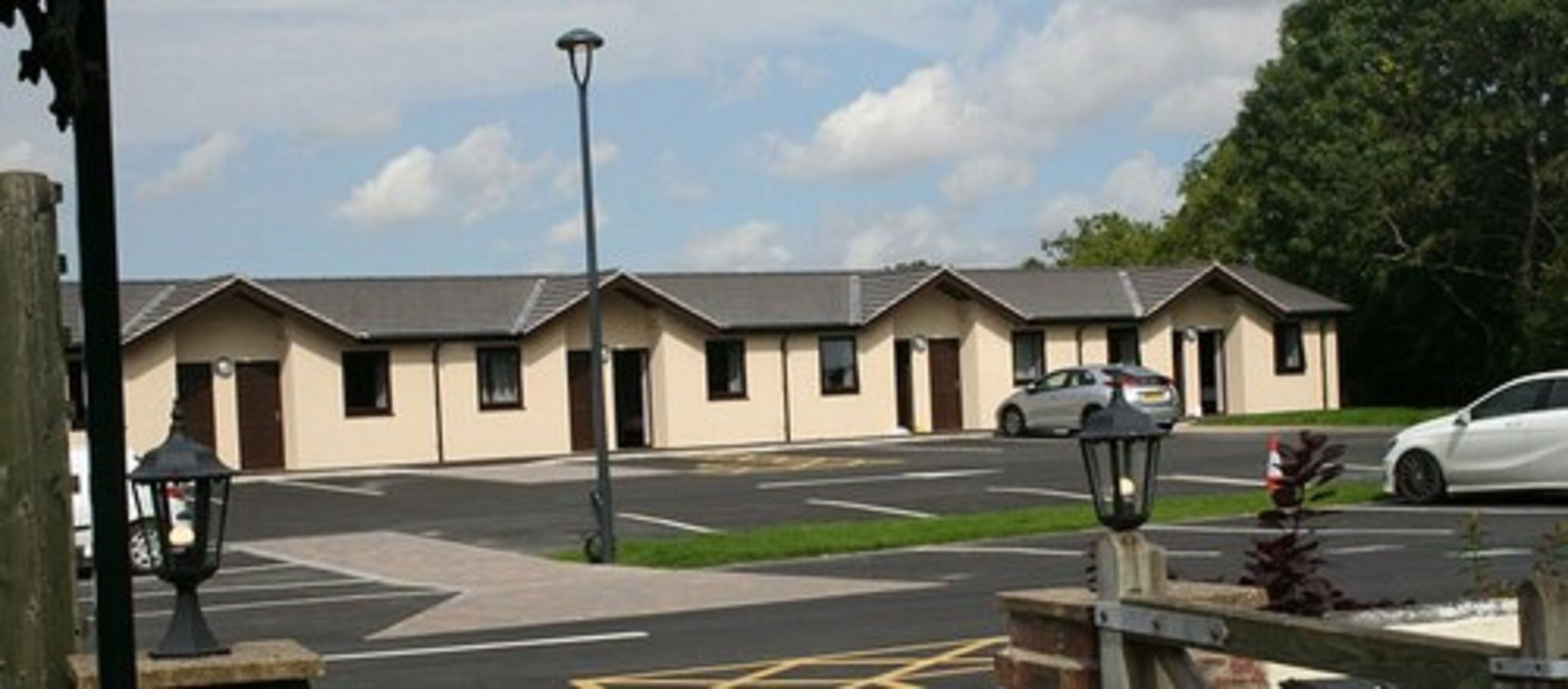 A row of single-story buildings with a parking lot in front.