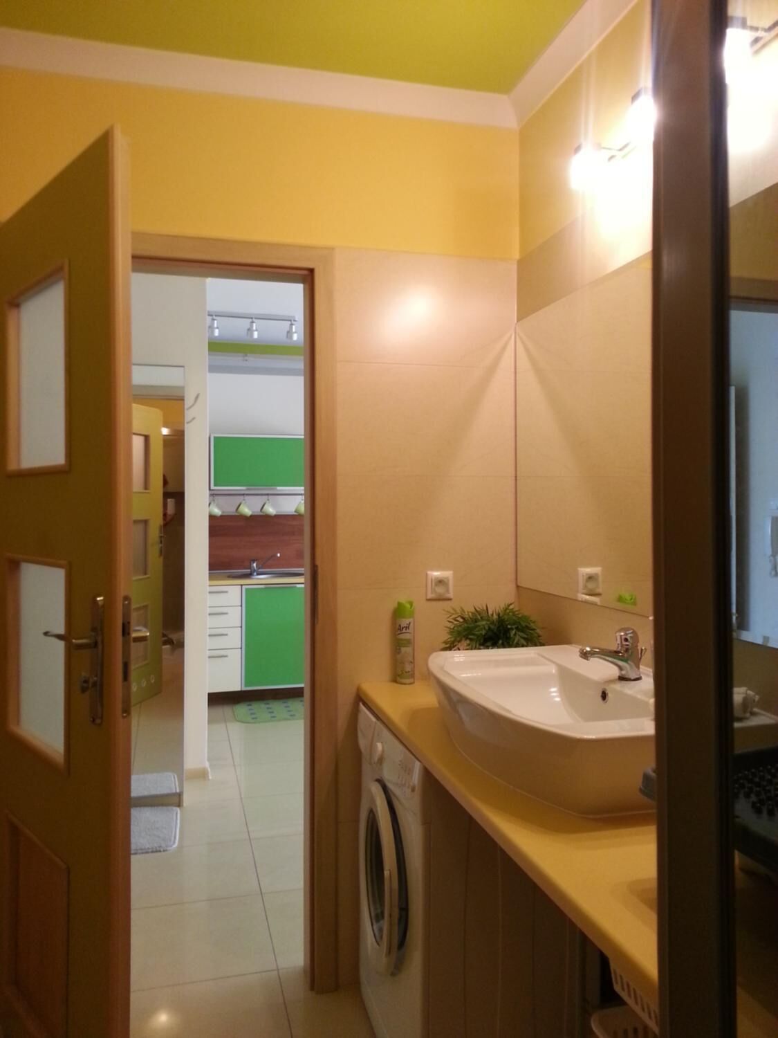 Ein kleines Badezimmer mit Waschbecken, Spiegel und Waschmaschine.
