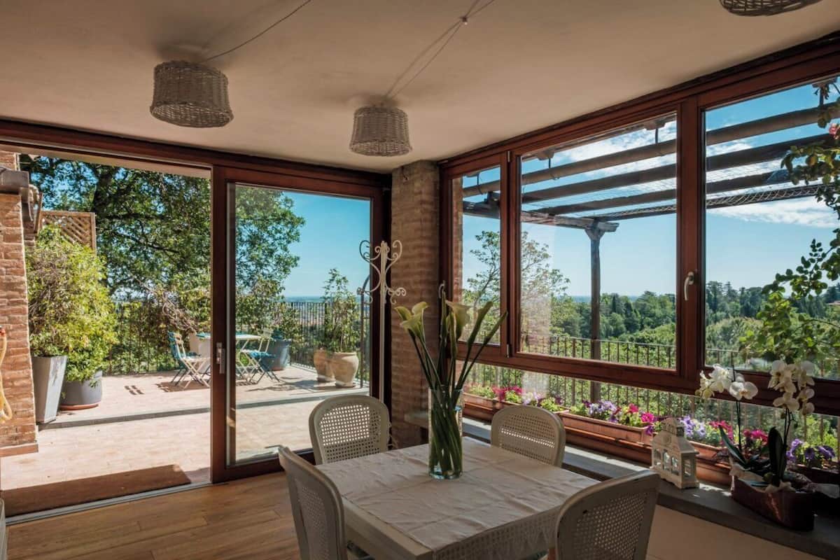 A dining area with a table, chairs, and a vase of flowers.