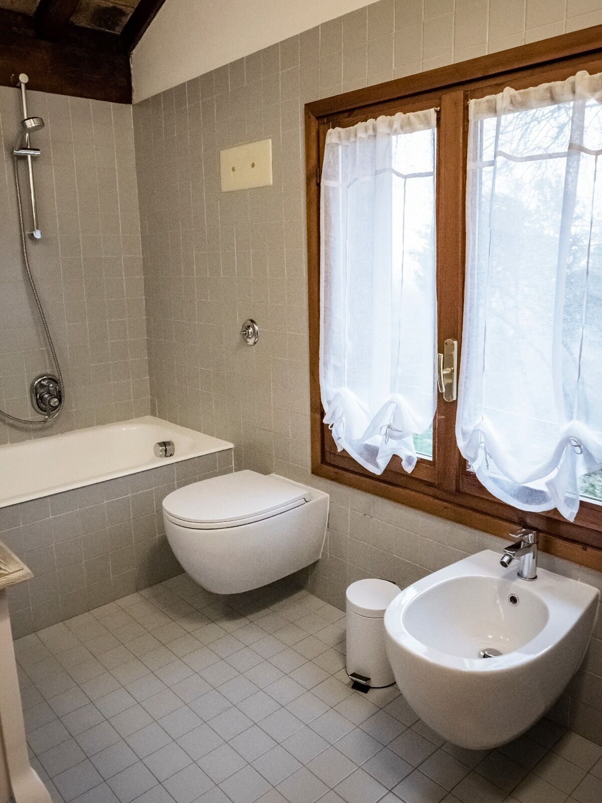 A bathroom with a toilet, bidet, bathtub, and sink.