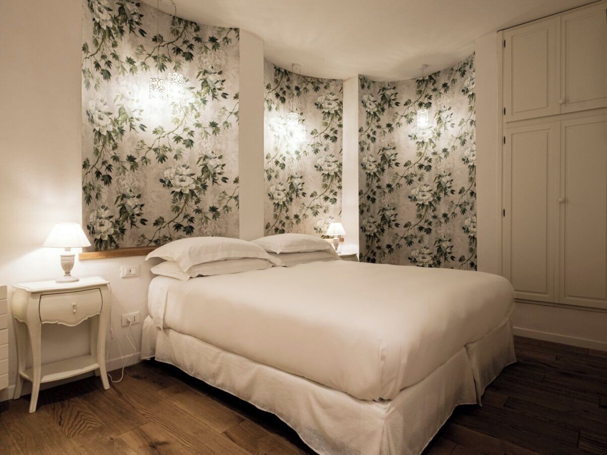 Een slaapkamer met een bed, nachtkastjes en een kledingkast.