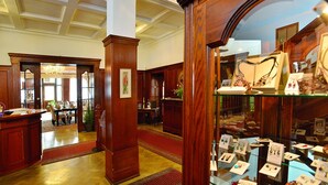 Eine Lobby mit Holzkubmöbeln, einem Empfangstresen und einer Schmuckausstellung.