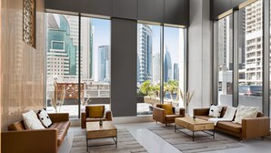 A modern living room with large windows, leather sofas, and a coffee table. - Wyndham Doha West Bay (Doha)