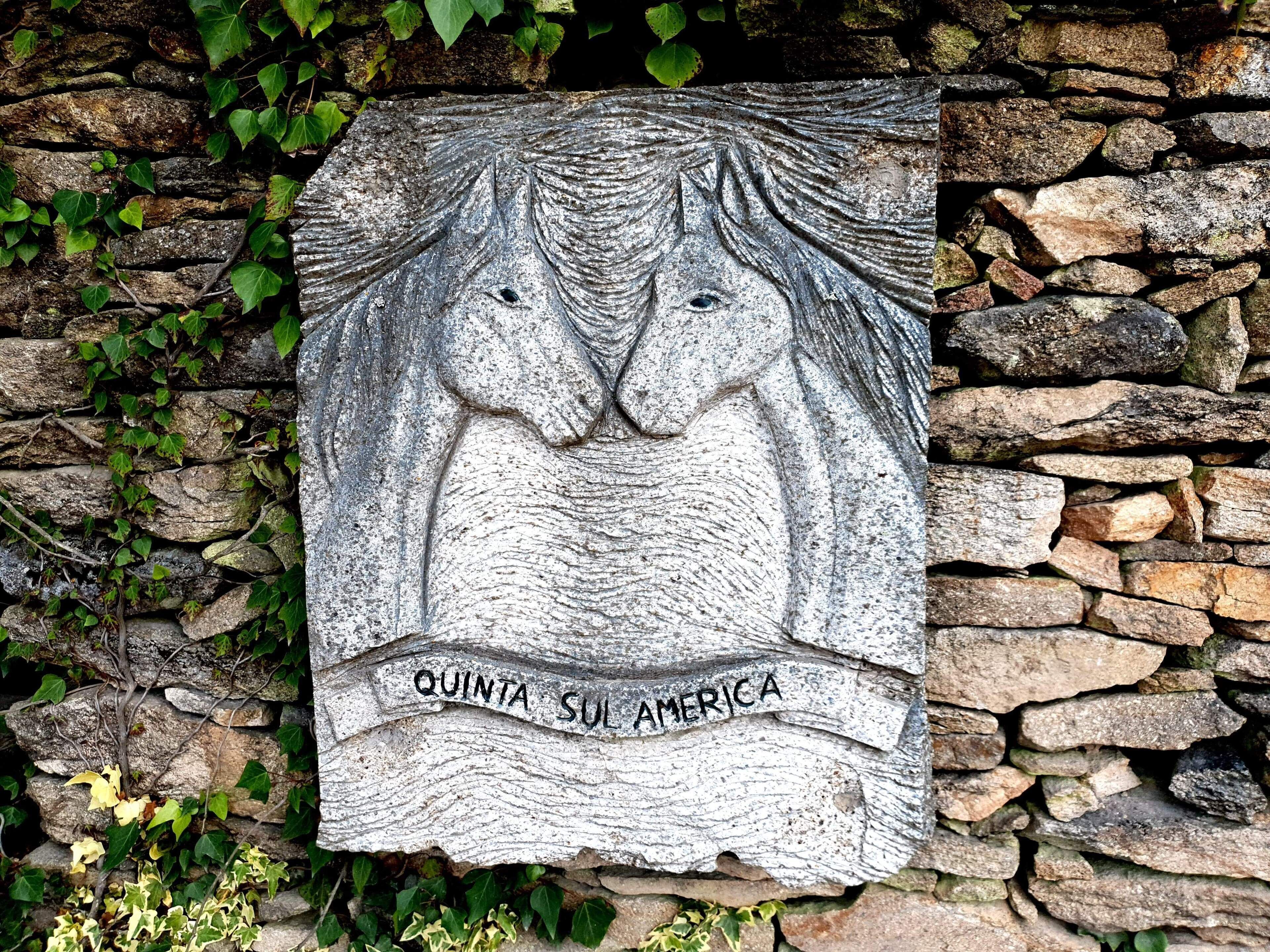 A stone plaque with a carved figure and the inscription "QUINTA SUL AMERICA".