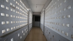 Un pasillo con suelo y paredes de azulejos, con numerosas aberturas cuadradas.
