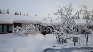 Un edificio con techo nevado y árboles circundantes.