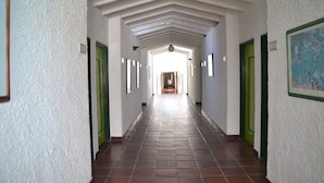 A corridor with white walls, green doors, and a tiled floor. - Hotel Albatros (Espinal)