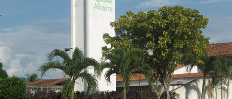 Un edificio alto y blanco con un logotipo que presenta una ola y la palabra 'Albatros'.