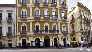 A multi-story building with a classical architectural style, featuring arched windows and balconies. - Art Fashion House Luxury Rooms (Catania)