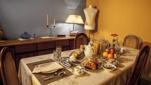 A dining table set with plates, glasses, and a variety of food items. - Art Fashion House Luxury Rooms (Catania)
