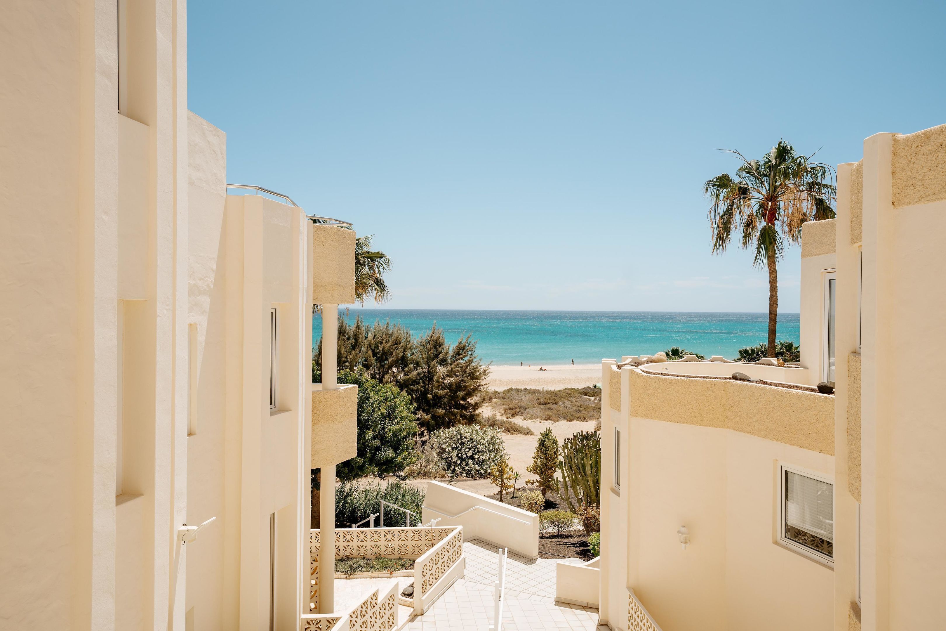 Blick vom Balkon auf einen Strand bei klarem Himmel.