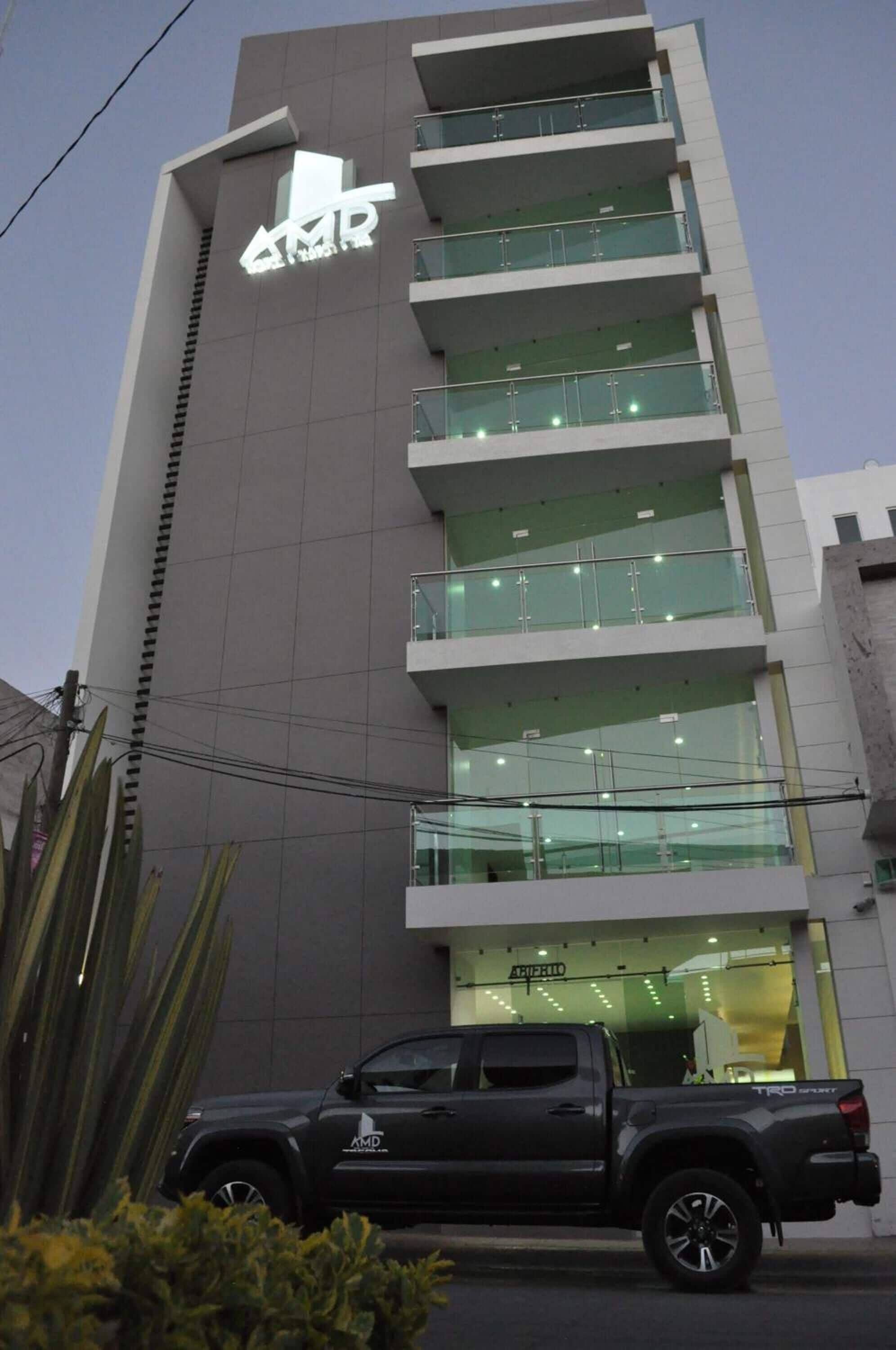 A multi-story building with a prominent sign reading "AMD".