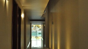 Un pasillo con vista a una piscina y un edificio a lo lejos.