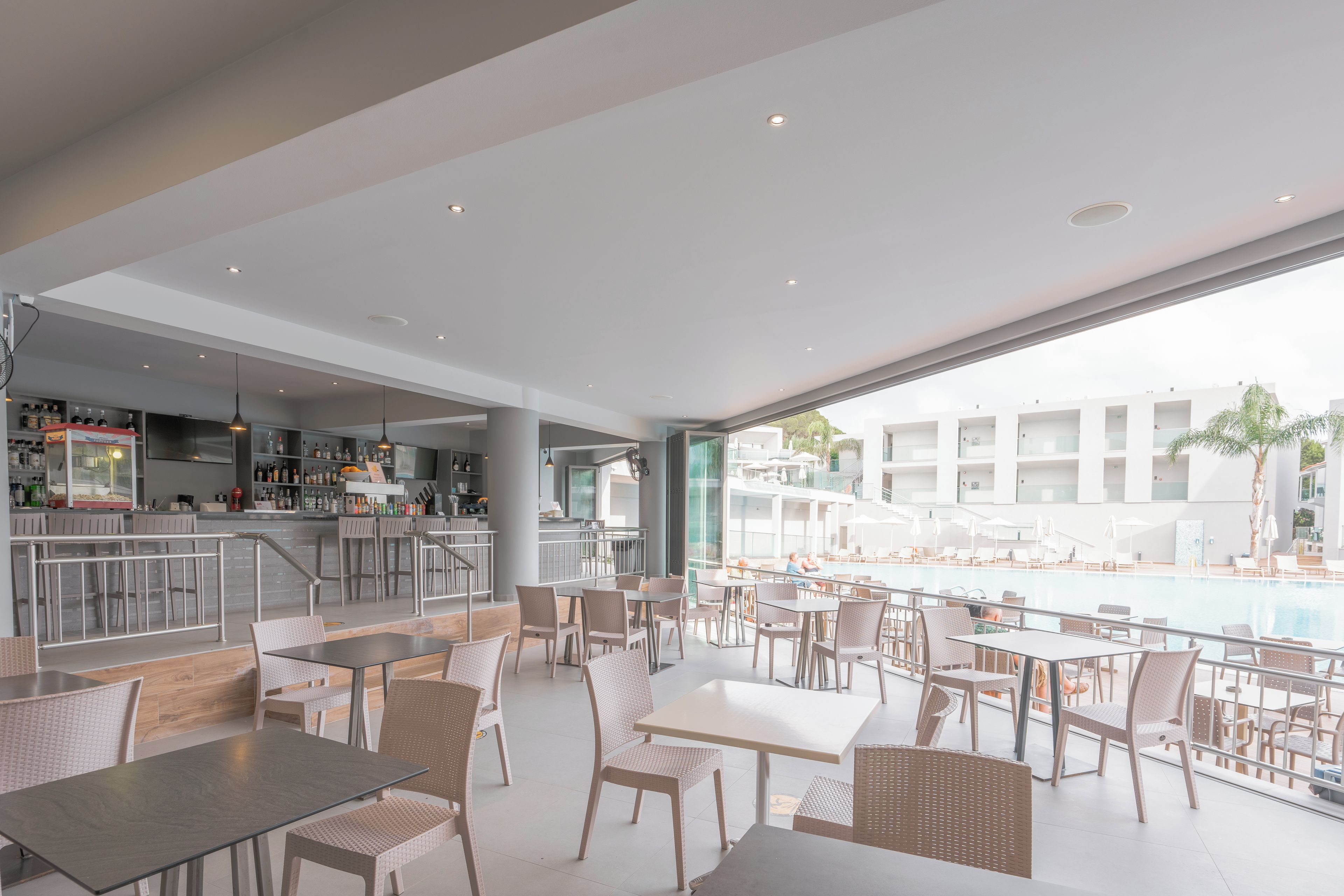 Uma área de bar moderna com espaço para sentar junto à piscina.