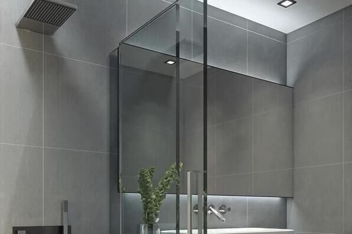 A modern bathroom with a glass-enclosed shower, a built-in sink, and a towel rack.