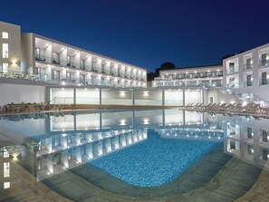 A modern hotel with a large indoor swimming pool, multiple balconies, and a well-lit exterior. - Zante Sun Resort (Zakynthos)
