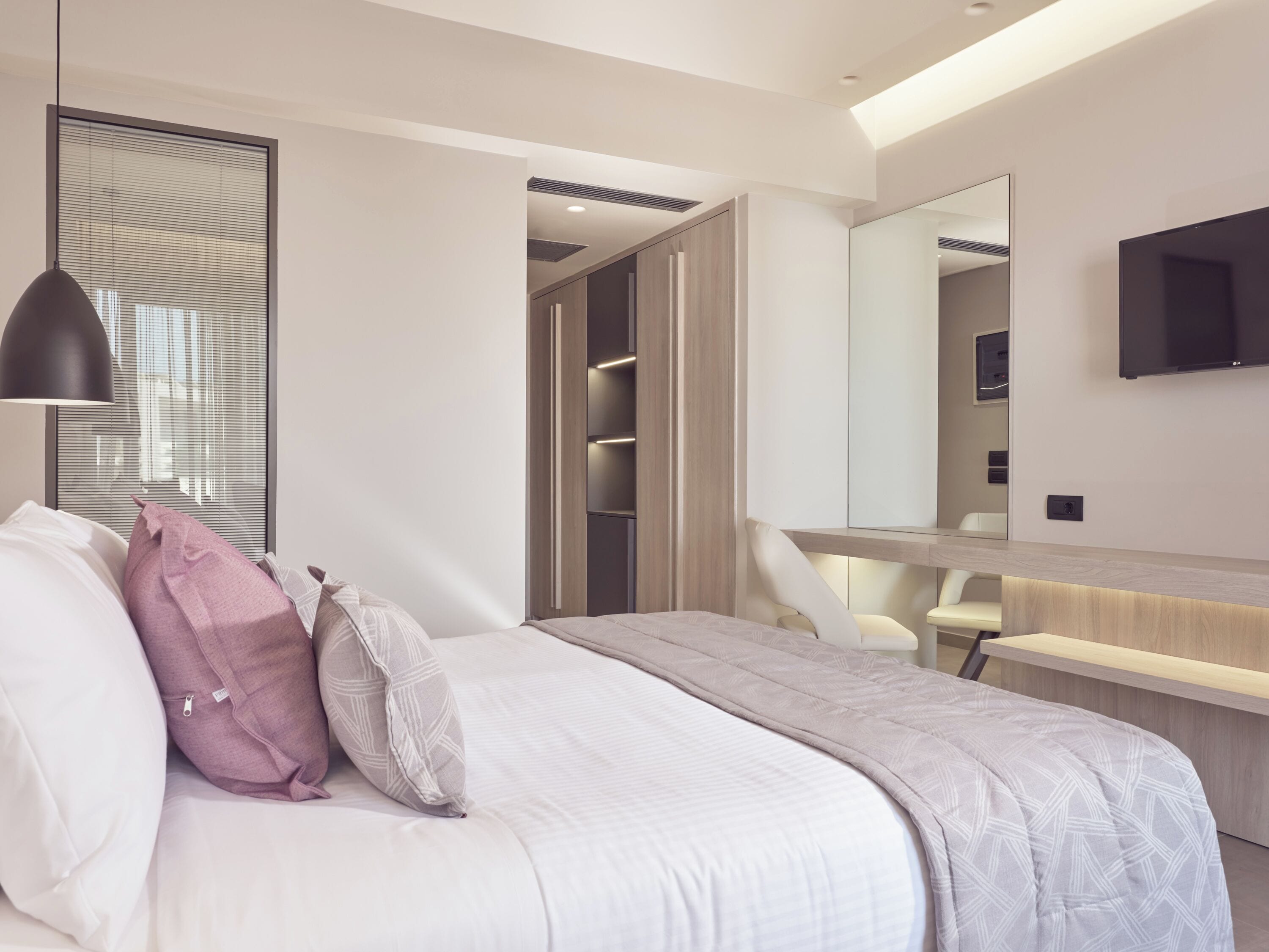 Una camera da letto moderna con un letto, un comodino e un grande specchio.