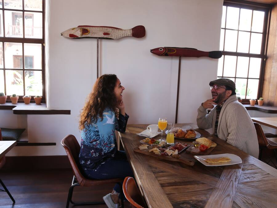 Un espace repas avec des tables et des chaises en bois, une variété de plats disposés sur les tables et des poissons décoratifs accrochés au mur.
