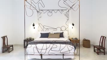 A modern bedroom with a unique metal frame bed, two bedside tables, and a nightstand.